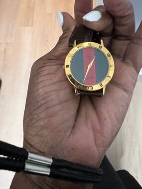 Gucci Gold-Tone Vintage Watch with Brown Leather Strap and Green/Red Dial.